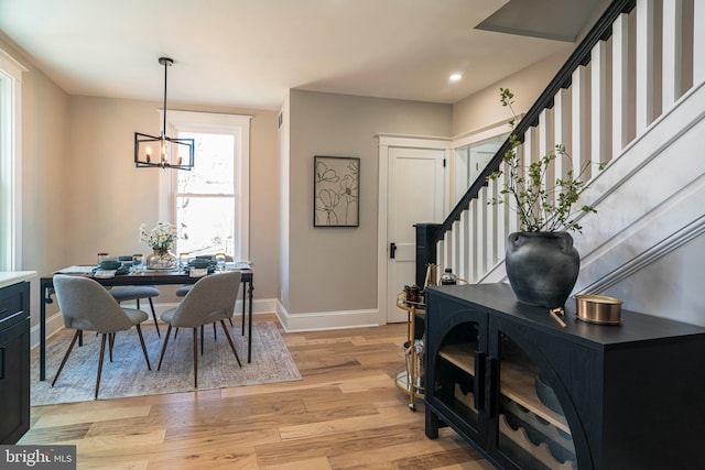 dining area with a chandelier, recessed lighting, baseboards, stairway, and light wood-type flooring