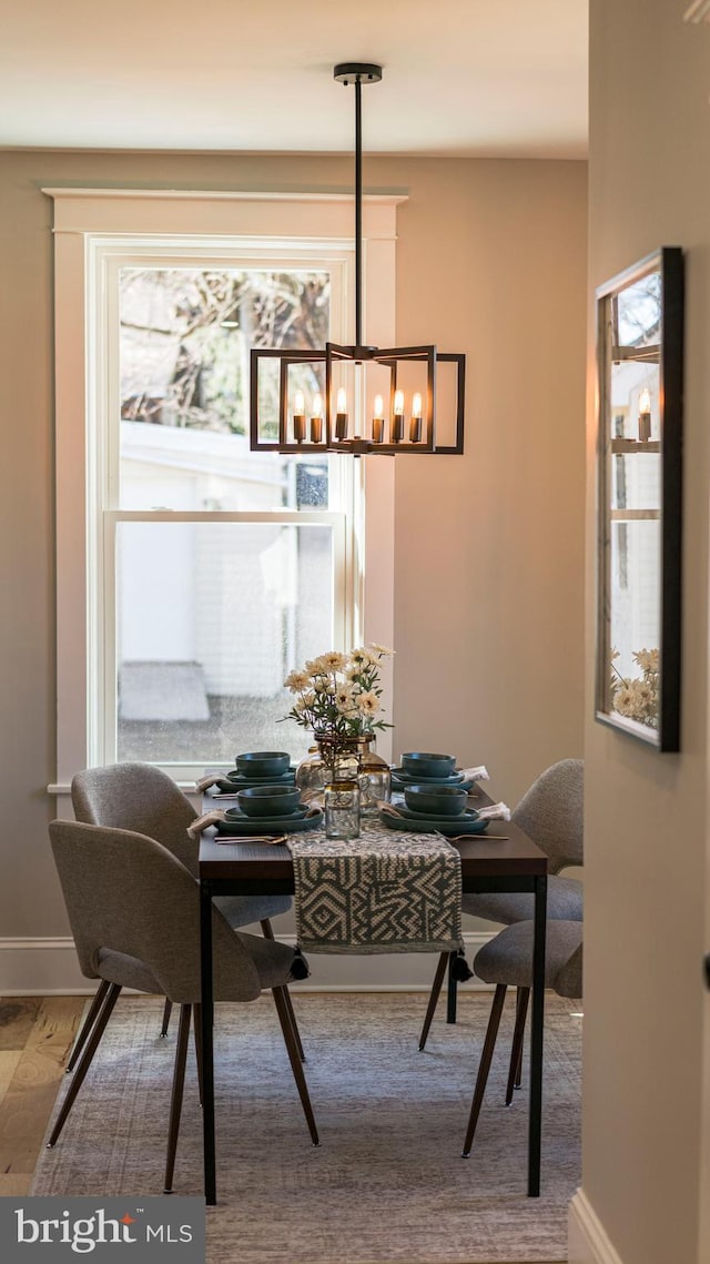 dining room featuring an inviting chandelier, baseboards, and wood finished floors