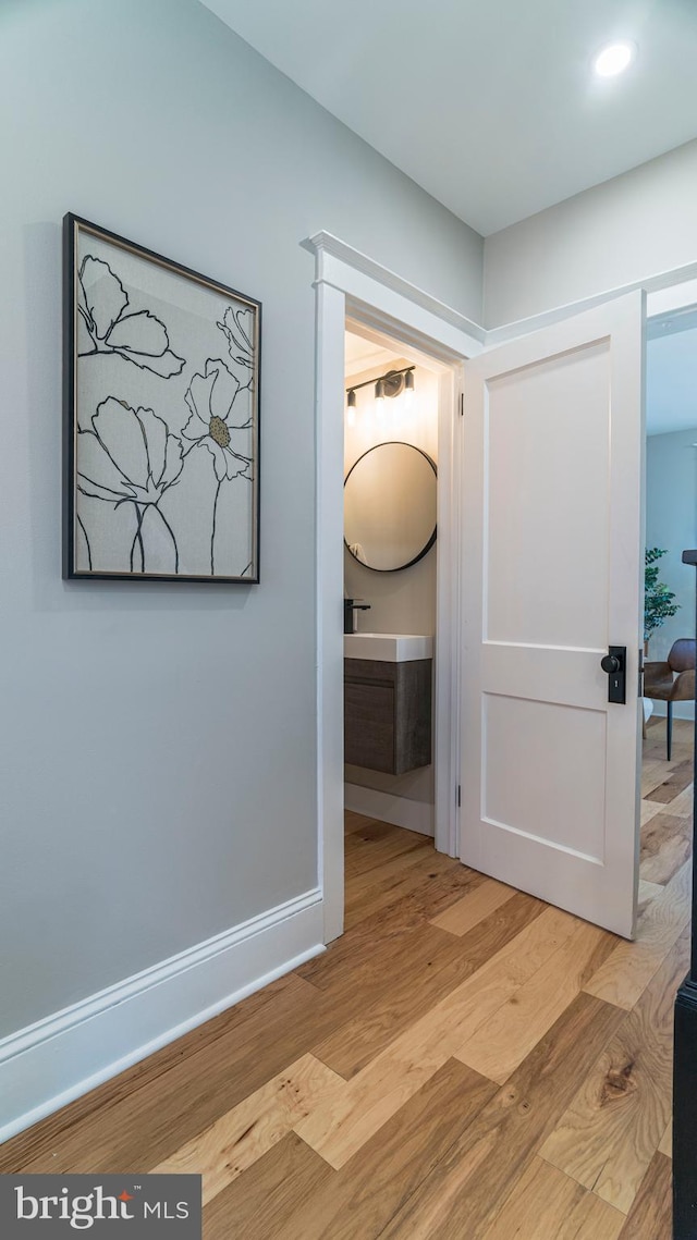 hallway with light wood-style floors and baseboards