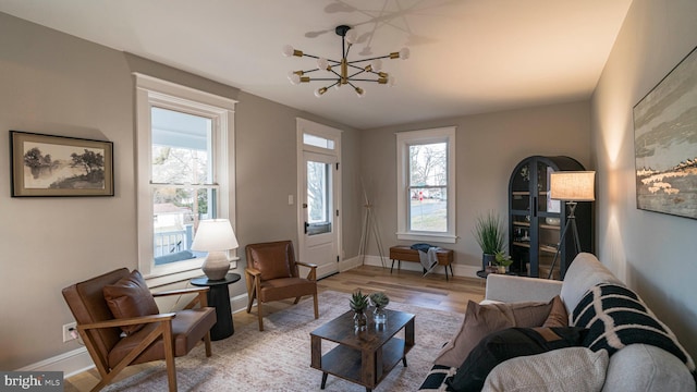 living room with a chandelier, wood finished floors, and baseboards