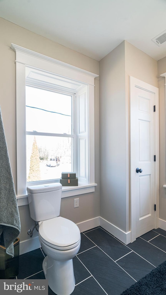 bathroom featuring toilet, tile patterned flooring, visible vents, and baseboards