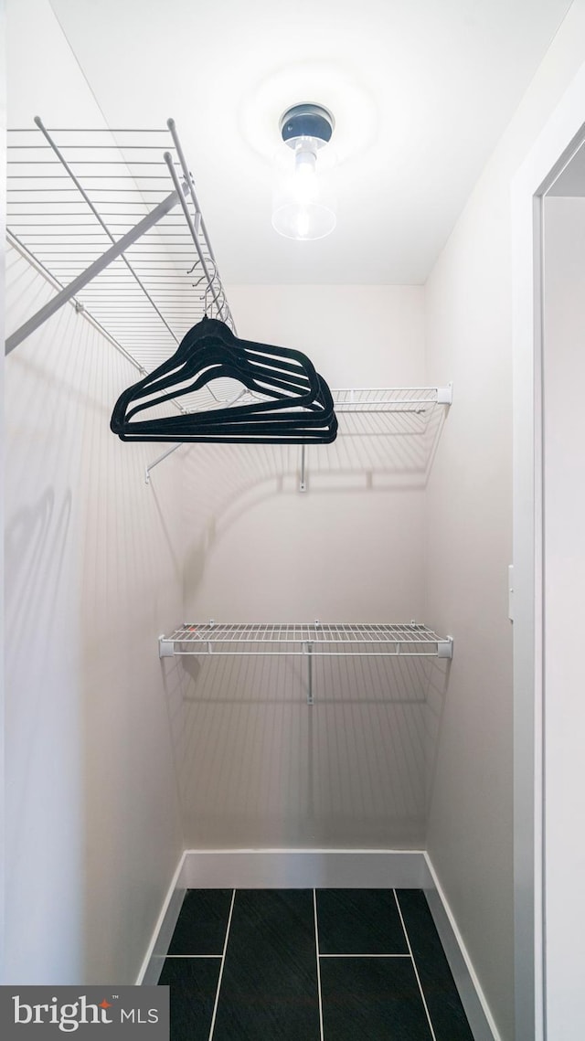 walk in closet featuring dark tile patterned floors