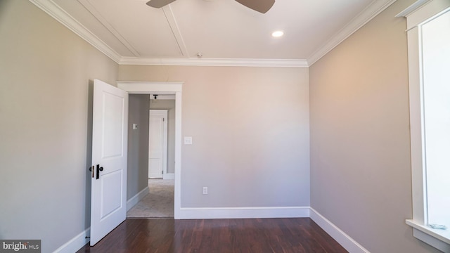 empty room with dark wood-style floors, attic access, crown molding, and baseboards