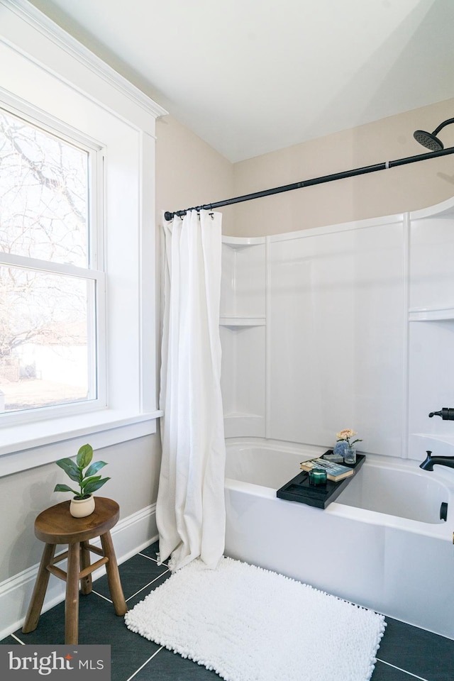 full bath featuring shower / tub combo and baseboards