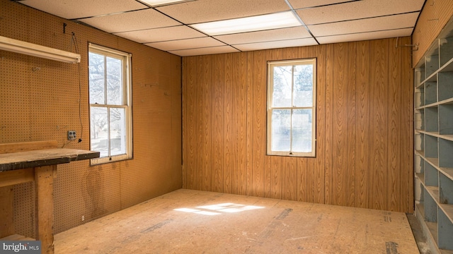 empty room featuring a paneled ceiling and a wealth of natural light