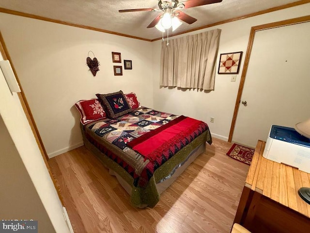 bedroom with ornamental molding, a ceiling fan, baseboards, and wood finished floors