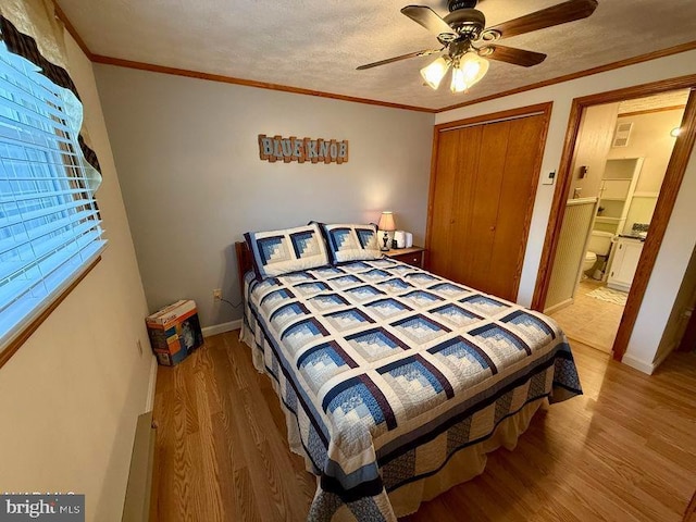 bedroom featuring ornamental molding, a textured ceiling, and wood finished floors