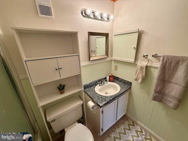 bathroom with toilet, visible vents, and vanity