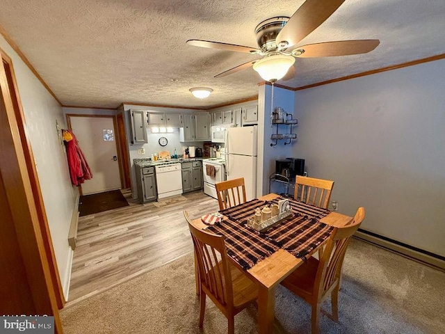 dining room with crown molding, light wood finished floors, a ceiling fan, a textured ceiling, and baseboards