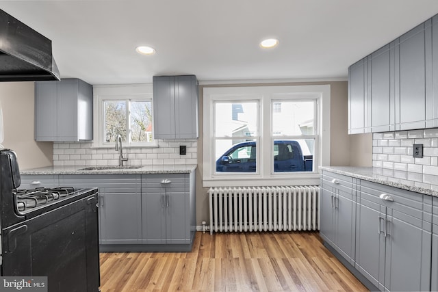 kitchen with radiator, a sink, and gray cabinetry