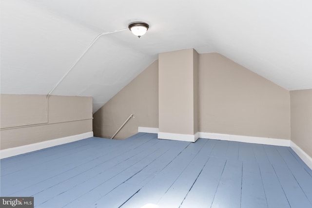 additional living space with vaulted ceiling, wood finished floors, and baseboards