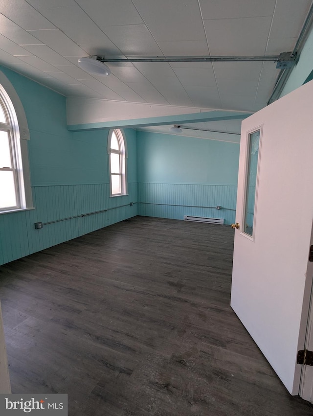 empty room with wood finished floors and wainscoting