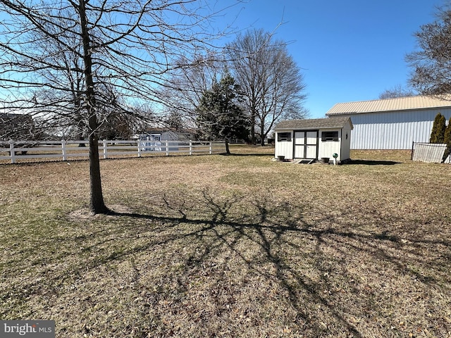 view of yard with a storage unit, fence, and an outdoor structure