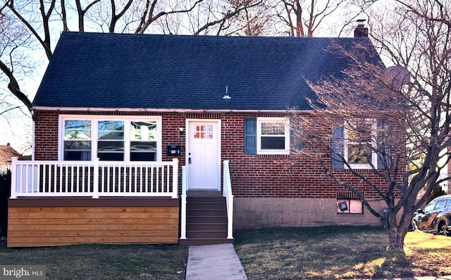 view of front of house with brick siding, roof with shingles, and a chimney