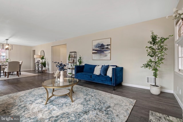 living room featuring wood finished floors, visible vents, and baseboards