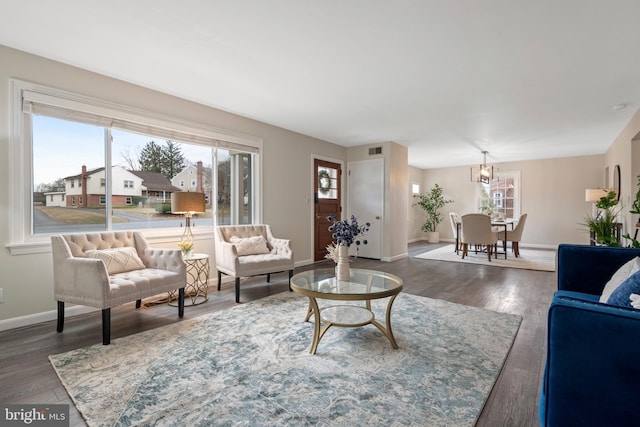 living area featuring wood finished floors, visible vents, and baseboards