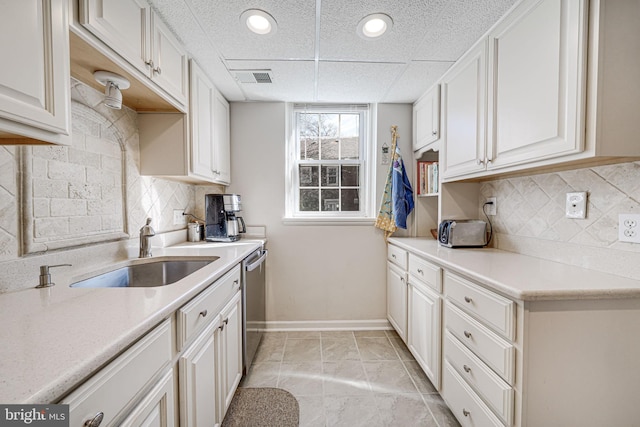 kitchen featuring a sink, baseboards, dishwasher, and light countertops