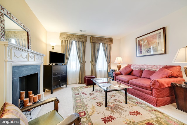 living room featuring a high end fireplace, visible vents, and carpet floors