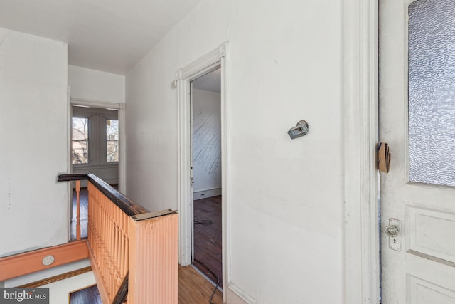 corridor featuring wood finished floors and an upstairs landing