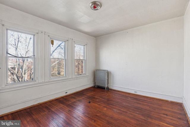 empty room with radiator and hardwood / wood-style flooring