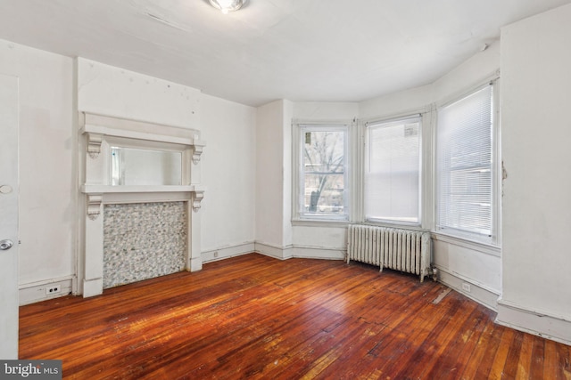 unfurnished living room featuring hardwood / wood-style flooring and radiator heating unit