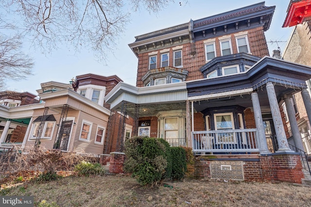 view of front of house featuring covered porch and brick siding