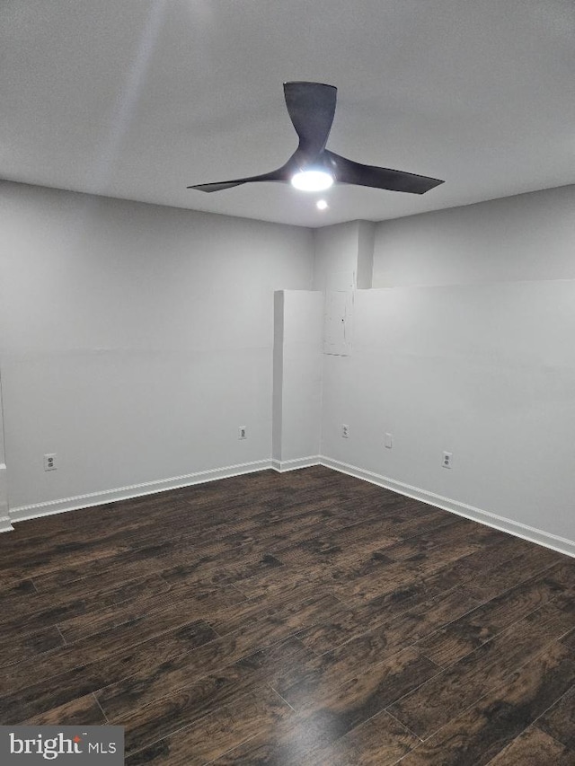 unfurnished room featuring dark wood-style floors, ceiling fan, and baseboards