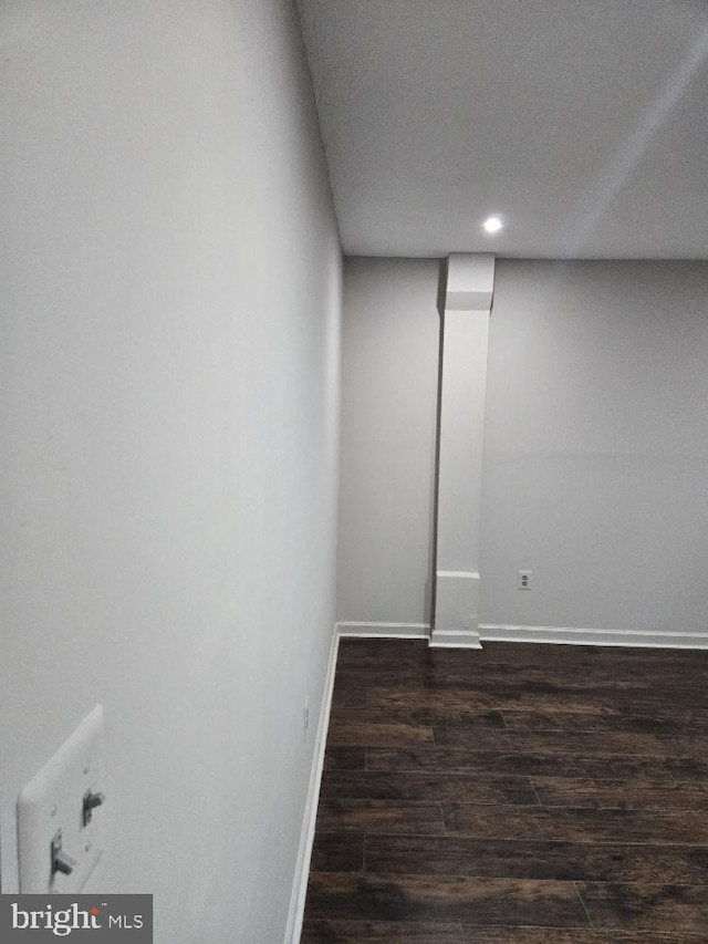 basement with dark wood-type flooring and baseboards