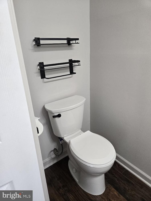 bathroom featuring wood finished floors, toilet, and baseboards