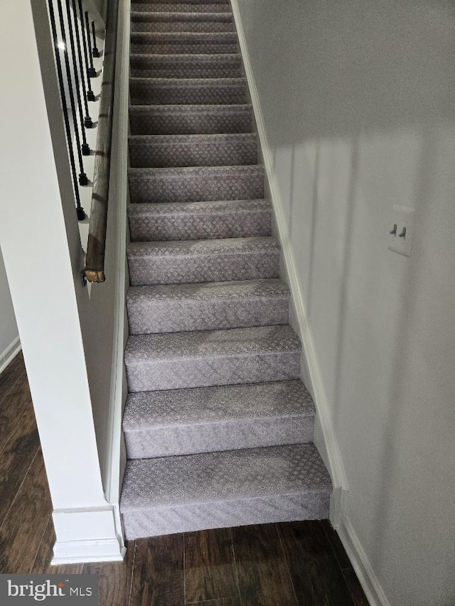 stairs with wood finished floors and baseboards