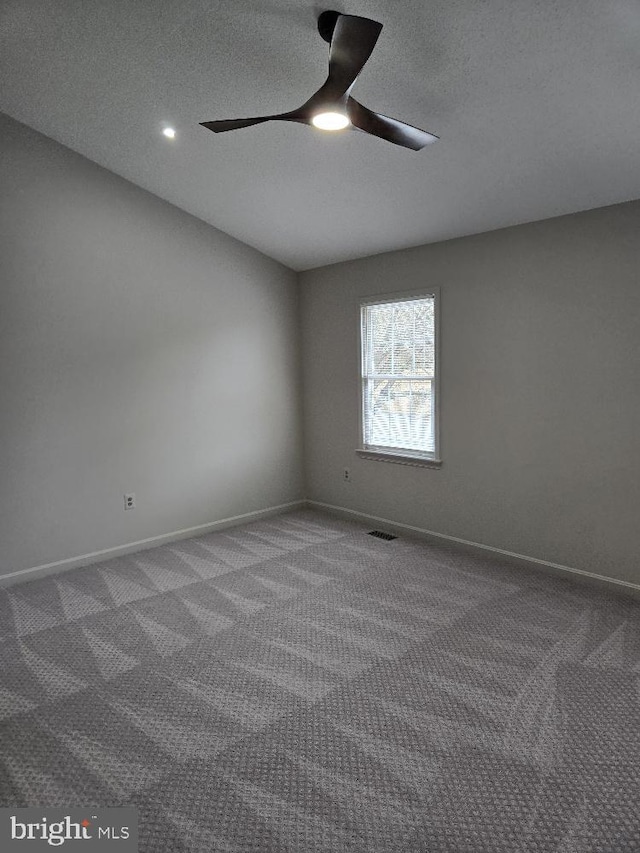 spare room featuring baseboards, visible vents, a ceiling fan, a textured ceiling, and carpet flooring