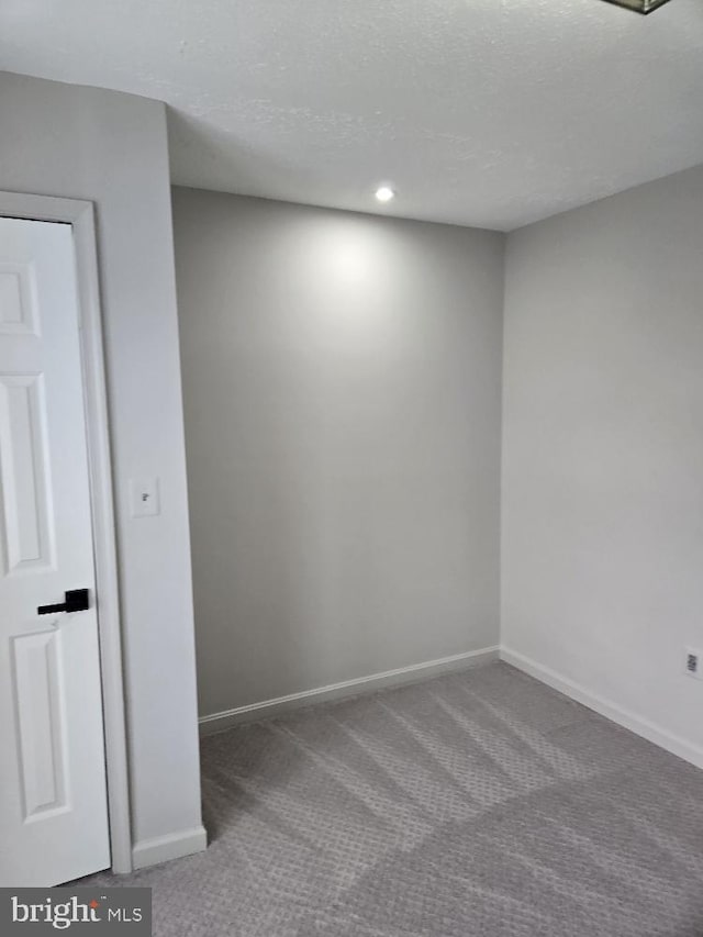 spare room with recessed lighting, carpet flooring, a textured ceiling, and baseboards