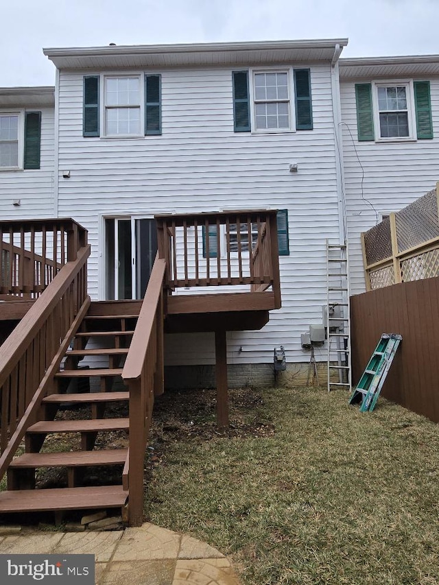 back of property featuring stairs, a yard, a wooden deck, and fence