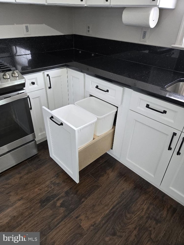 kitchen featuring stainless steel range, dark wood finished floors, and white cabinetry