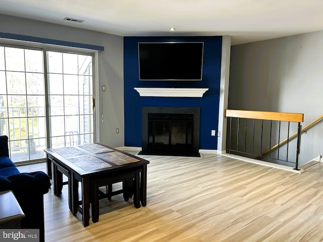 living room featuring a fireplace, wood finished floors, and visible vents