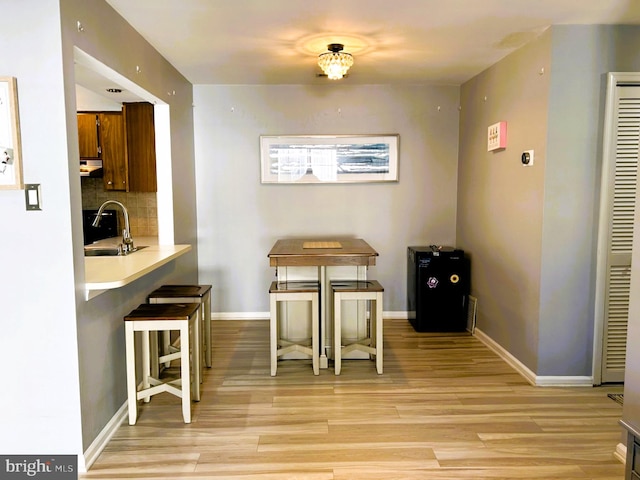 dining space featuring baseboards and light wood finished floors