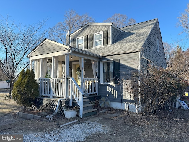 bungalow-style house with a shingled roof and covered porch