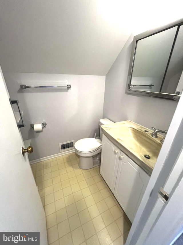 half bath featuring visible vents, tile patterned flooring, vanity, toilet, and lofted ceiling