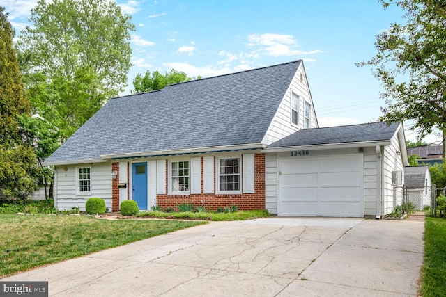 cape cod house featuring brick siding, a front lawn, concrete driveway, an attached garage, and a shingled roof
