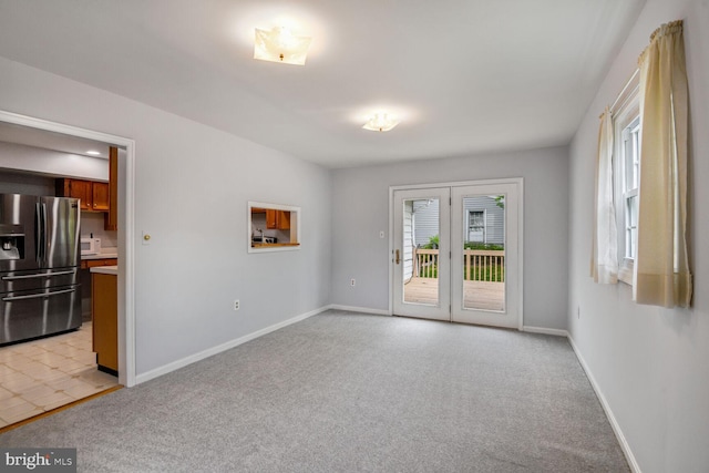 unfurnished room featuring plenty of natural light, baseboards, and light colored carpet