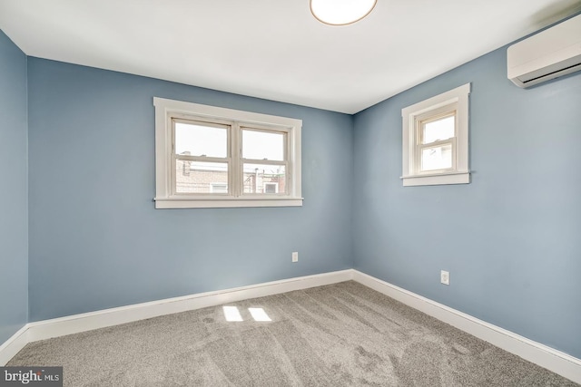 spare room with carpet floors, baseboards, and a wall mounted air conditioner