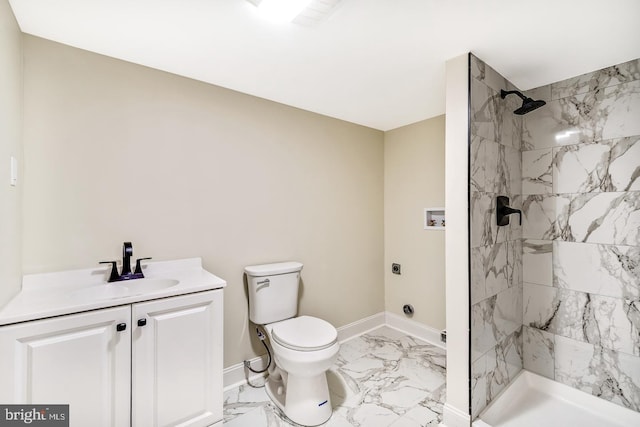 bathroom featuring baseboards, tiled shower, toilet, marble finish floor, and vanity