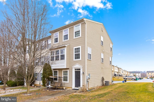 view of property with central AC unit and a front yard