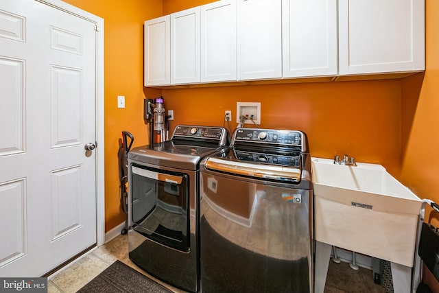 washroom featuring washer and dryer, tile patterned floors, cabinet space, and a sink