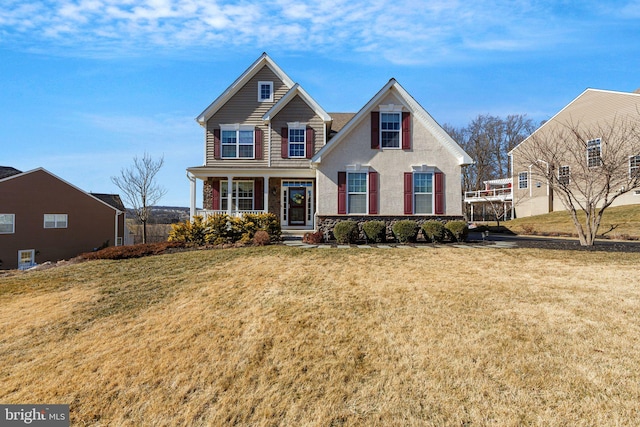 traditional-style home featuring covered porch and a front lawn