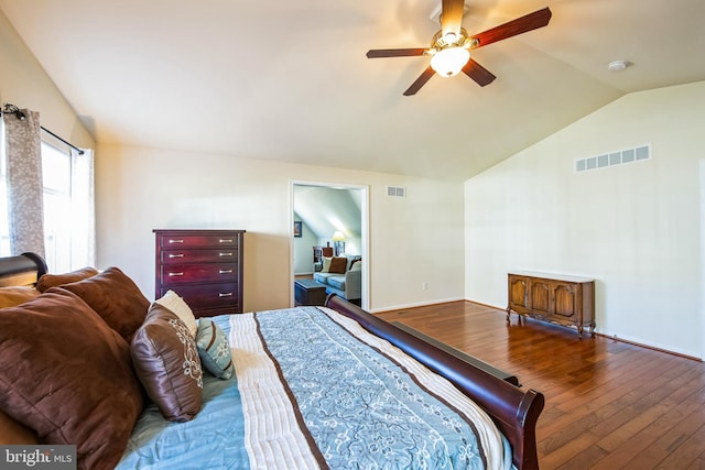 bedroom featuring visible vents, hardwood / wood-style flooring, a ceiling fan, and vaulted ceiling