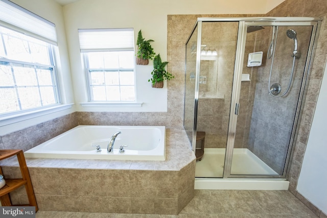 bathroom featuring a shower stall and a bath