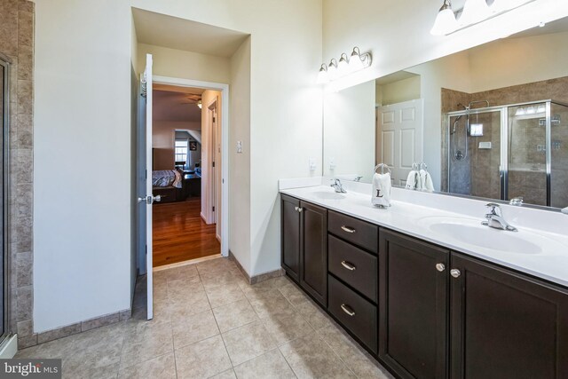 full bathroom with a stall shower, a sink, connected bathroom, tile patterned flooring, and double vanity