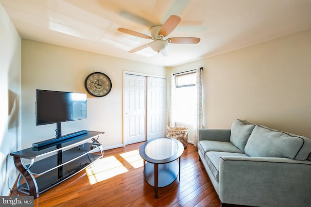 living room featuring baseboards, ceiling fan, and wood-type flooring