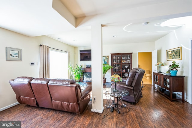 living area with baseboards and wood finished floors